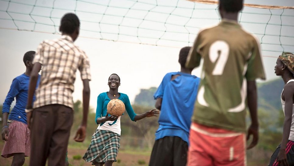 Ethiopia / South Sudanese Refugees / Nyaboul (center), 15,a student at Tierkidi refugee camp's main school, which has over 6000 pupils including a football pitch, volleyball net and child-friendly spaces. She fled with her 3 siblings from South Sudan when the war came to her village in Mathang. she thinks that she is an orphan and now tasked with looking after her brothers, she draws strength from sport. "I lost my mother and my father was killed, so it's just me and my brother here alone. I play volleyball at the school all morning. I just want to be a good player. Our team is called 13. When I play, I feel strong and healthy. I'm the only girl on the team, but I don't think I play better than the boys." / UNHCR / C. Tijerina / November 2014