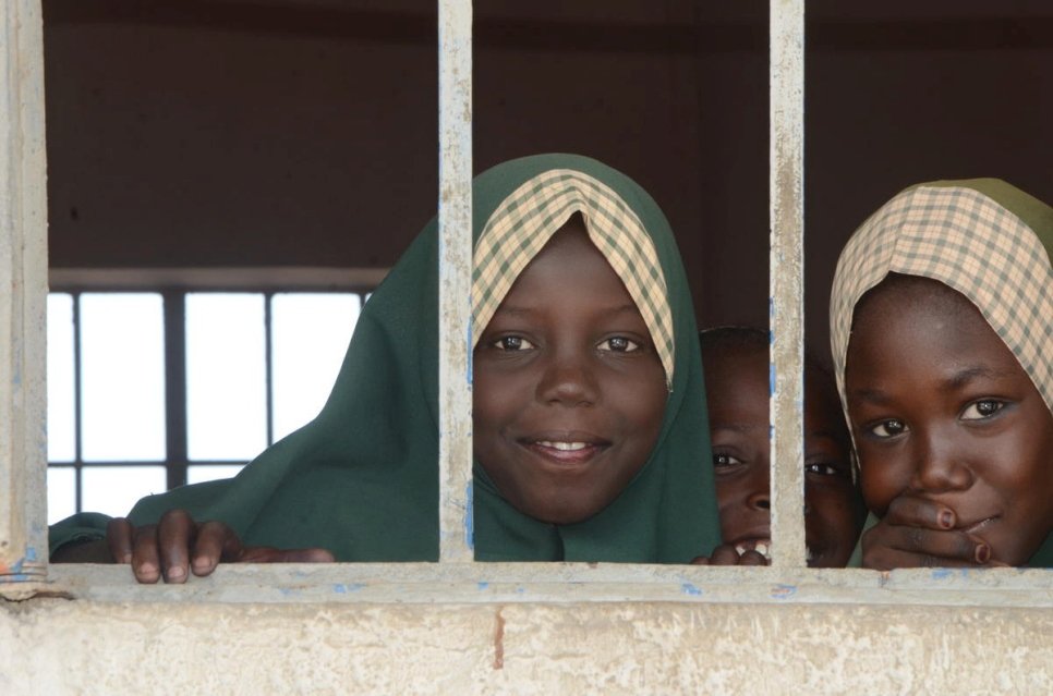 Displaced Nigerian girls peep through the window of their class at one of four schools established by Nansen Refugee Award Laureate, Zannah Mustapha in Borno State, Nigeria.