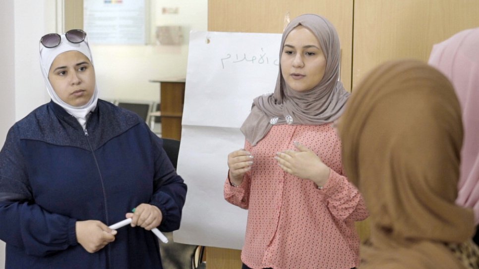 Syrian refugees, Nabila Berm (left) and Sura Al Azami, brainstorm ideas on tackling gender-based violence with the community youth group they founded in Amman, Jordan.
