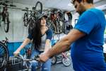 Sulaf, a Palestinian refugee displaced from Damascus, Syria, tests a bicycle for size with the help of Jim Stein, the founder of The Bike Project in London. The volunteer initiative refurbishes second-hand bikes for refugees and asylum-seekers.