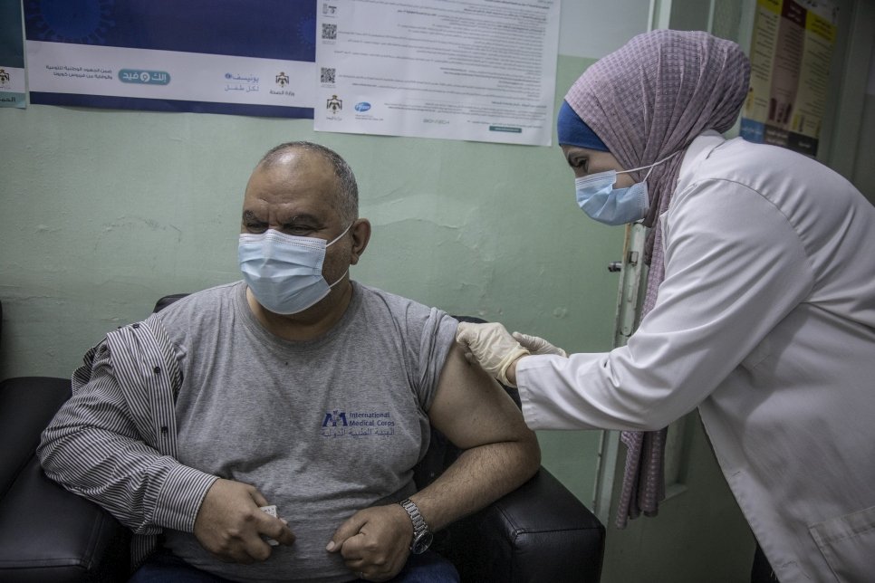 Iraqi refugee Ziad receives a dose of COVID-19 vaccine at the Irbid Vaccination Clinic in Jordan.
