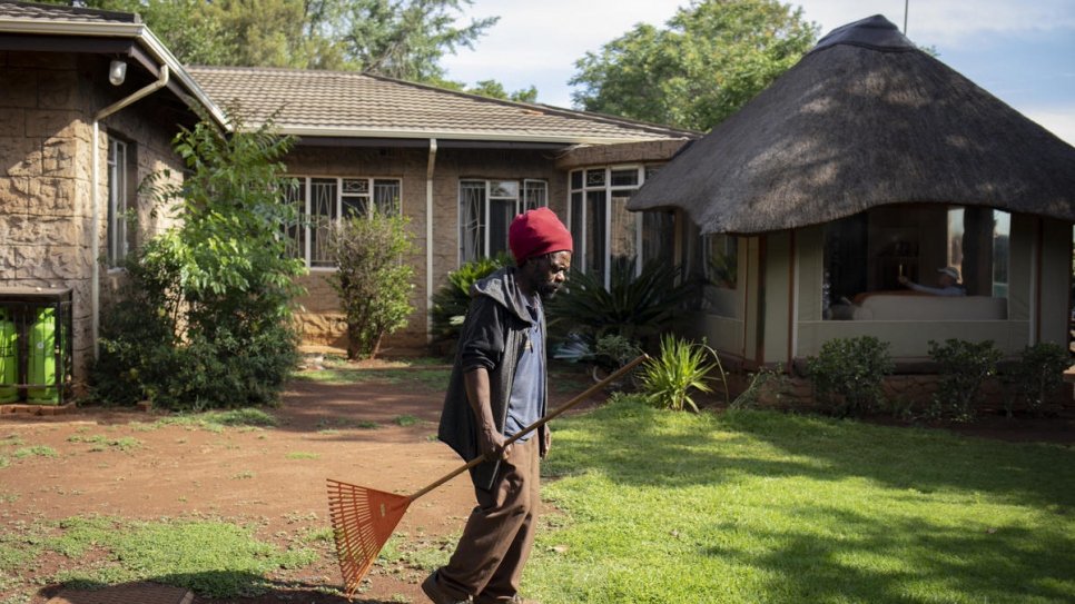 Raphael Chauke walks across the compound where he works as a gardener in Pretoria, South Africa. 