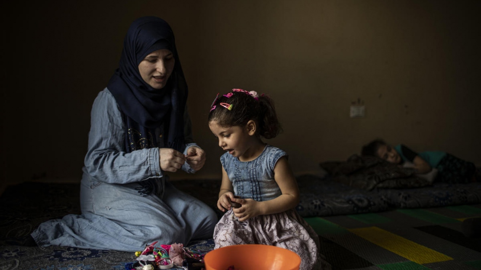 Syrian refugee Wafaa pins daughter Yasmine's hair at their home in Barja, Lebanon.