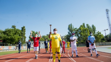 Personas refugiadas y atletas de Special Olympics marchan con la torcha olímpica en una jornada deportiva en Alcobendas, Madrid, en junio de 2021. 
