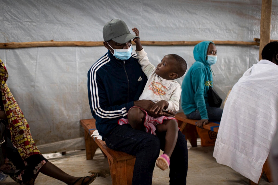 Le rapatrié burundais Donatien, 35 ans, est assis avec sa fille au centre de transit de Kinazi à Muyinga, au Burundi. 