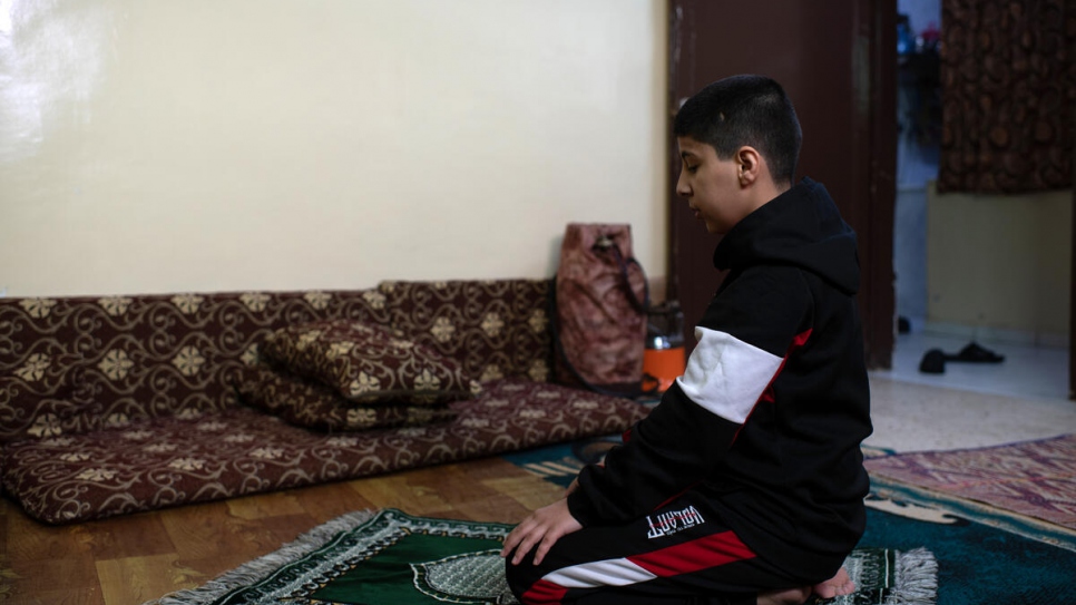 Dans l'appartement familial, Ali, 12 ans, prie avant le début du mois sacré du Ramadan. 