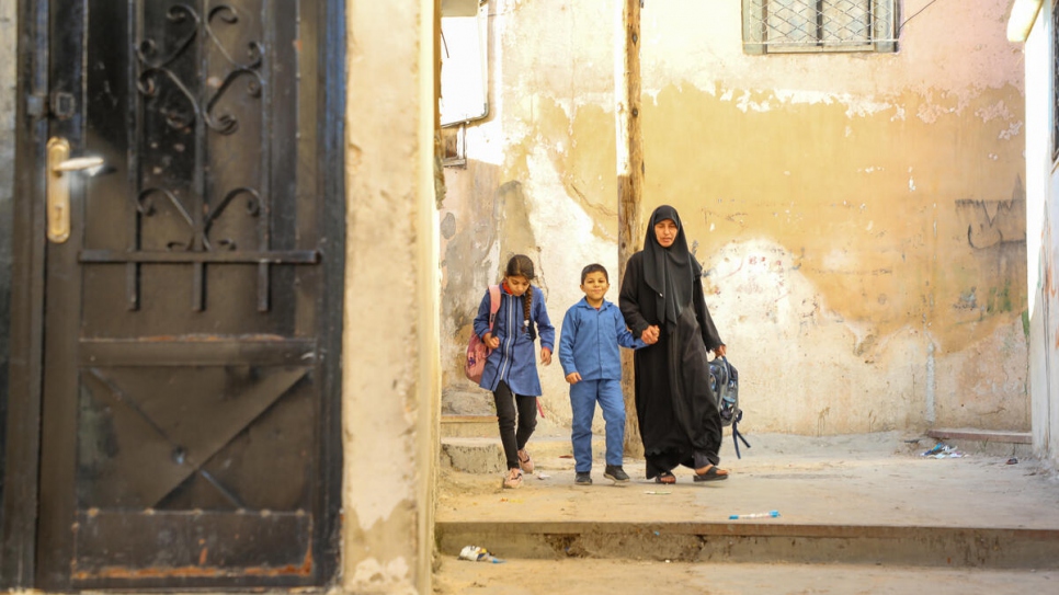 Aïcha, 10 ans, et Ahmed, 8 ans, rentrent à pied chez eux avec leur tante Huda avant la récente fermeture des écoles due à la pandémie de Covid-19. 