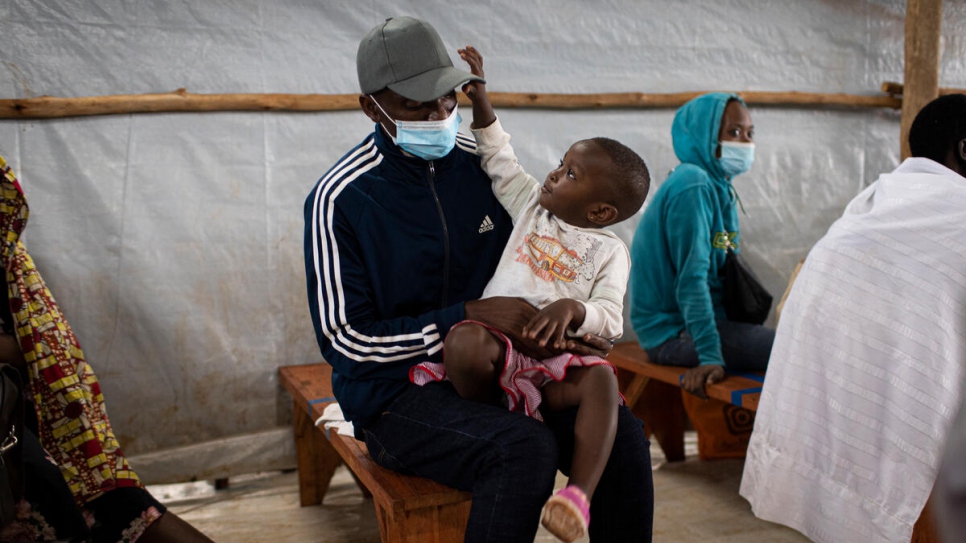 Donatien, un retornado burundés de 35 años, sentado junto a su hija en el centro de tránsito de Kinazi en Muyinga, Burundi.