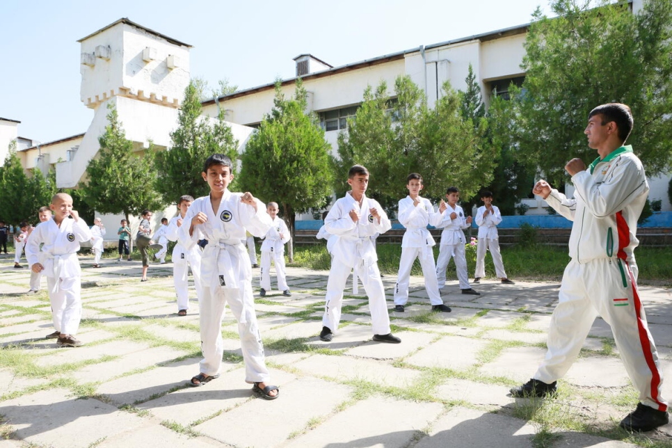 Estudiantes refugiados y locales dan una demostración de Taekwondo en una escuela en la ciudad de Vahdat, Tayikistán. 