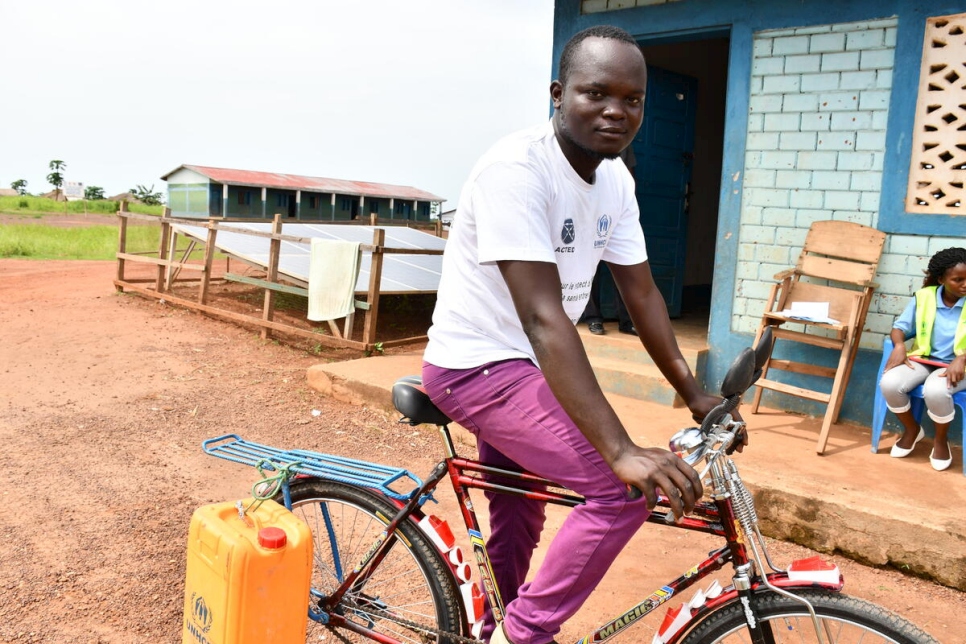 Thierry de 27 años, un refugiado de la República Centroafricana, recorre en su bicicleta el campamento de Inke, República Democrática del Congo, para promover buenas prácticas de higiene.