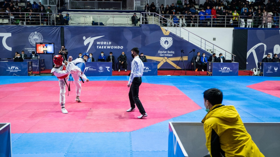 Mukhamadjon regarde un de ses élèves concourir dans les locaux de la Fédération de Taekwondo. 