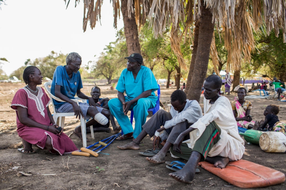Le docteur Evan Atar s'entretient avec des patients devant l'hôpital de Bunj dans le comté de Maban, au Soudan du Sud. 