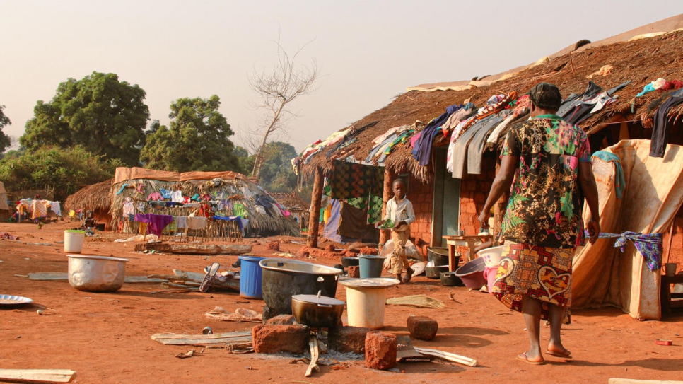 Une réfugiée centrafricaine et son enfant marchent devant un abri dans le village de Ndu, dans la province du Bas-Uele, en République démocratique du Congo.