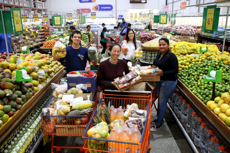 Venezolanos acogidos en una Aldea Infantil SOS en São Paulo realizan compras en el mercado de la capital paulista.