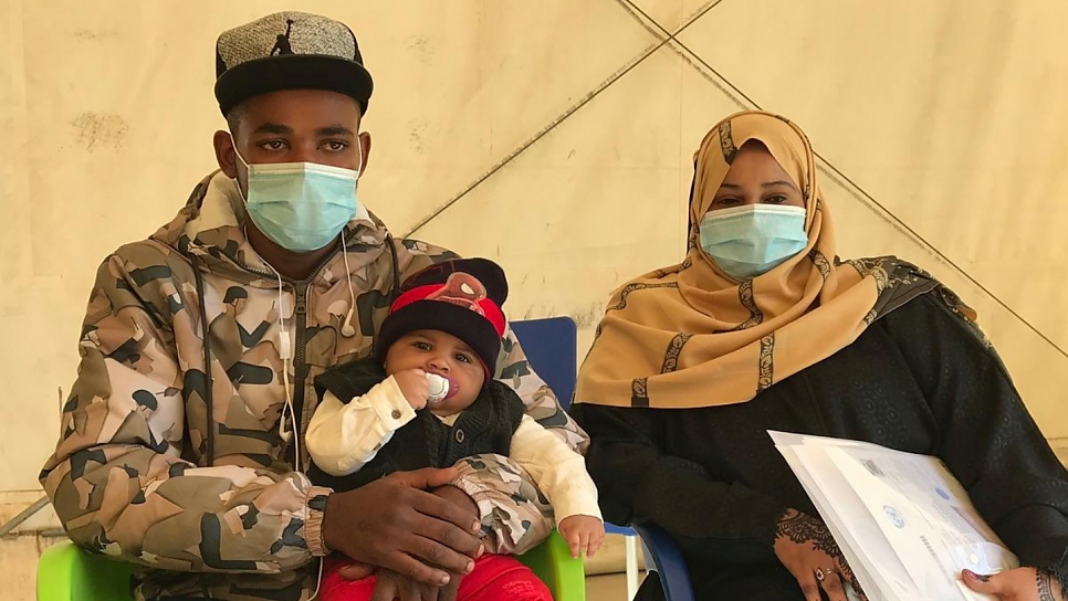 Los solicitantes de asilo somalíes Fawaz, de 21 años, Adnan, de cuatro meses, y Farah, de 24 años, se preparan para tomar el vuelo de evacuación humanitaria de Libia a Ruanda.