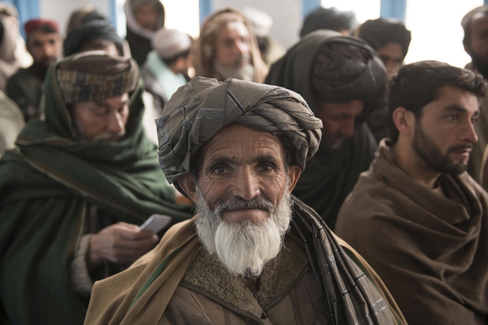 Mohammed Daud (centro) espera con otros hombres afganos en la ciudad de Kandahar para recibir la tercera parte de su subsidio en efectivo del ACNUR para construir una casa para él y su familia (2 de febrero de 2020). 
