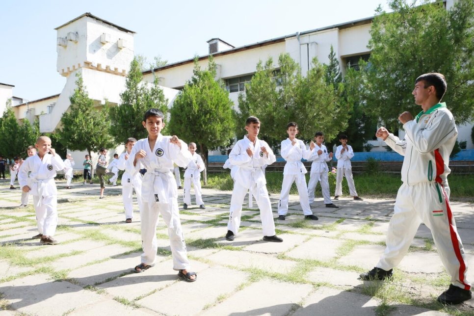 Des élèves réfugiés et locaux font une démonstration de taekwondo dans une école de la ville de Vahdat, au Tadjikistan.  