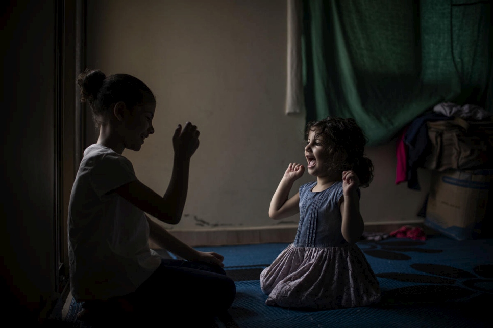 Layan, de 10 años, juega con su hermana menor, Yasmine, de 3 años. 
