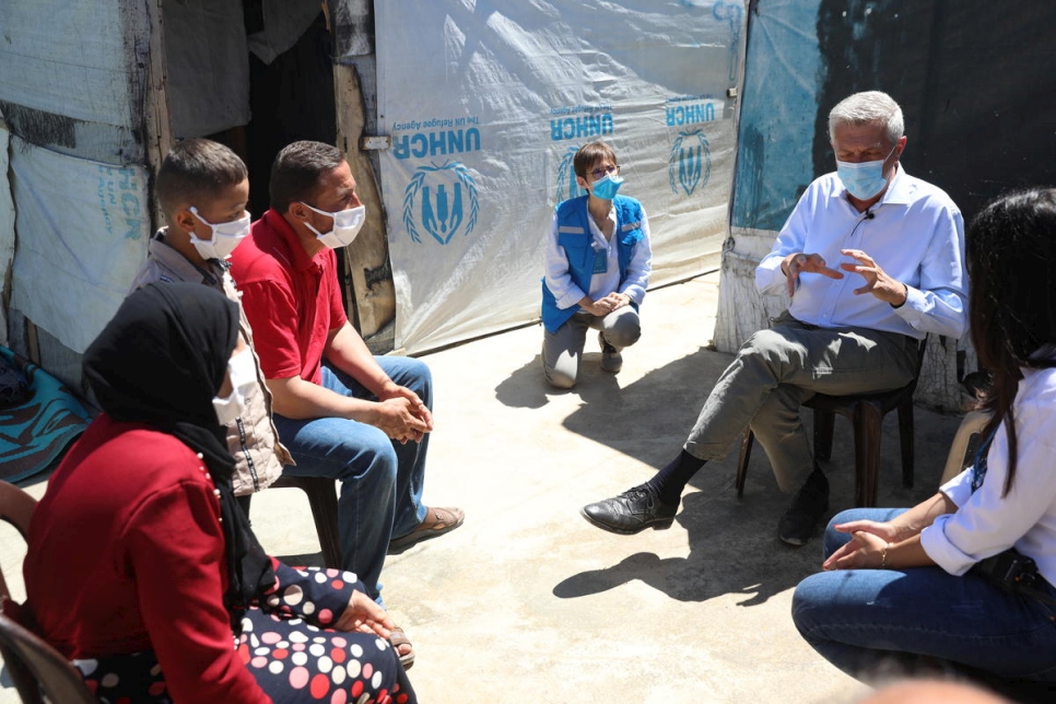 Grandi habla con Khalil y su familia fuera de su casa en un asentamiento informal de tiendas de campaña en el valle de Bekaa en el Líbano. 