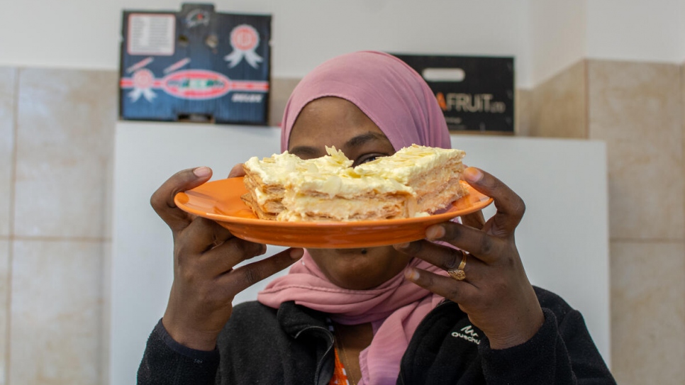 Mariam (34 ans), originaire d'Érythrée, présente son tout premier millefeuille, réalisé lors d'un atelier de cuisine au centre de transit d'urgence de Timisoara, en Roumanie. Février 2021 