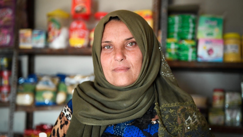 Abeer se tient dans l'épicerie qu'elle a ouverte grâce à une subvention pour les petites entreprises financée par le HCR. 