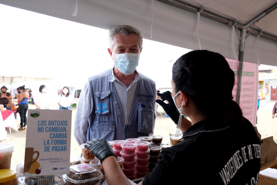 Le Haut Commissaire des Nations Unies pour les réfugiés, Filippo Grandi, s'entretient avec Carmen*, une demandeuse d'asile nicaraguayenne, près de son stand dans un marché d'Upala, au Costa Rica. 