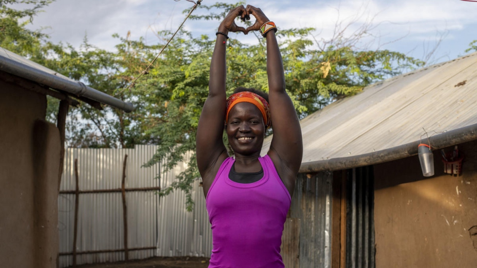 Rita Brown, réfugiée ougandaise et instructrice de yoga, prend une pose de yoga à l'extérieur de son logement dans le camp de Kakuma, au Kenya. 