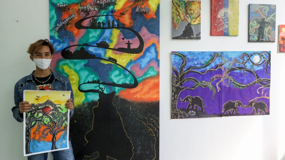 Anthony presenta sus pinturas durante su primera exposición artística en el albergue Rondon 2, con motivo del Día Mundial del Refugiado en 2020. 