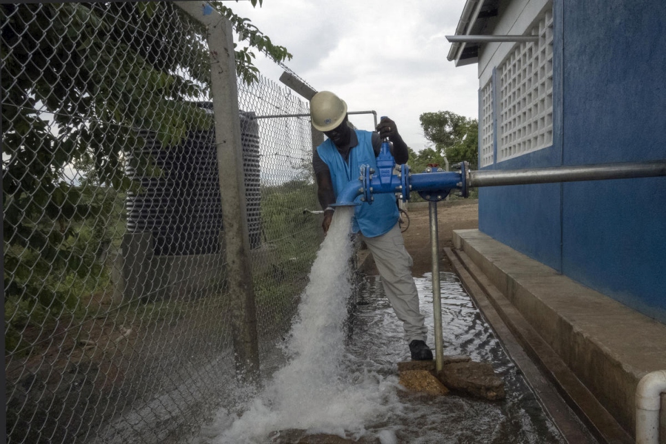 Richard Ochaya, oficial de agua, saneamiento e higiene, abre el suministro de agua en el proyecto de Obomiri para distribuir agua al campamento de refugiados de Bidibidi a través de pozos y bombas accionadas mediante energía solar. 