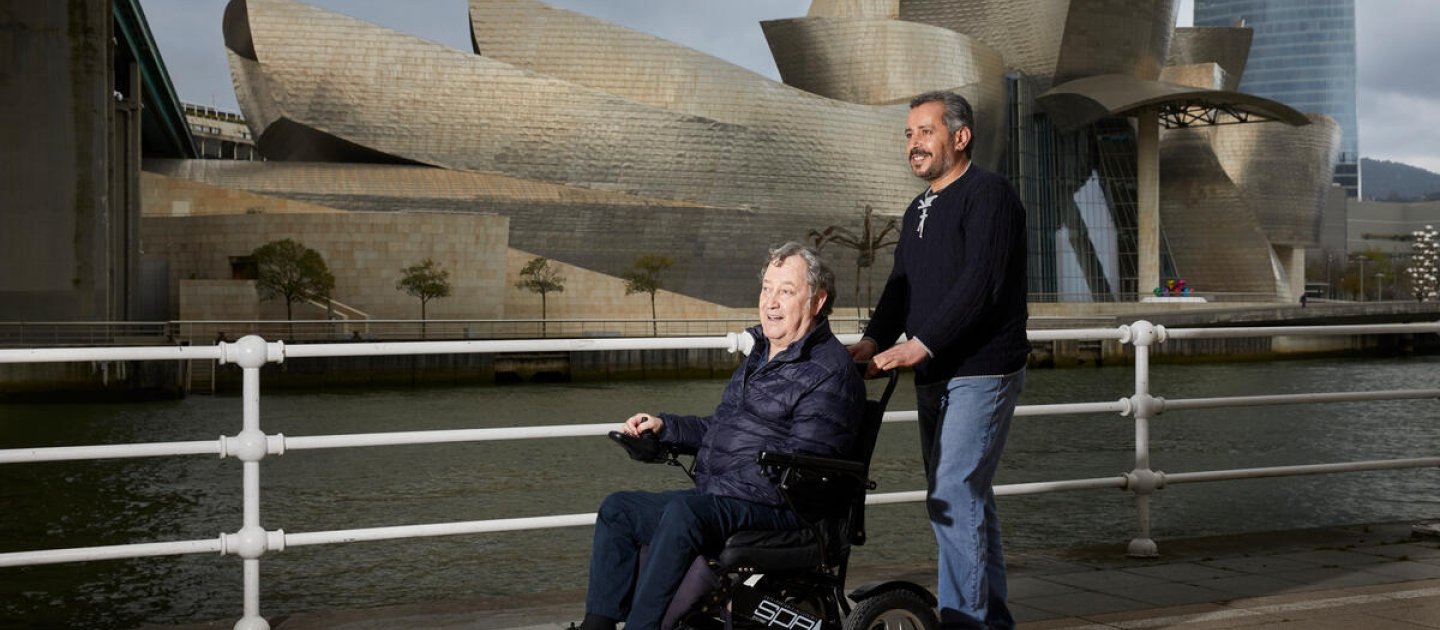 Majed, un refugiado sirio reasentado en Bilbao, pasea con su amigo y empleador, Joseba Gerrikaetxebarría, cerca del Museo Guggenheim.