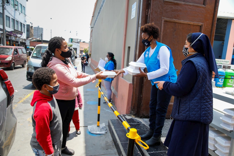 Juliette Murekeyisoni del ACNUR con voluntarios venezolanos en el Santuario Virgen de Lourdes en Lima. La organización entrega cientos de almuerzos todos los días a venezolanos y otros necesitados. 