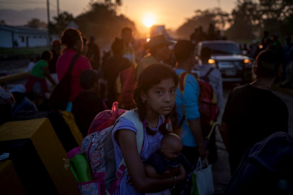 Nesta foto de fevereiro de 2020, Ipteehal, 9, brinca com sua irmã do lado de fora do prédio inacabado, onde moram com outras famílias deslocadas em Al Mukalla, no Iêmen