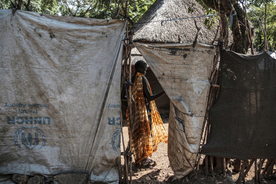La menor no acompañada de Sudán del Sur, Nyamach Lul, de 16 años, se encuentra en la puerta de la casa que comparte con su hermana Nyakoang, de 13 años, en el campamento de refugiados Jewi de Etiopía. 