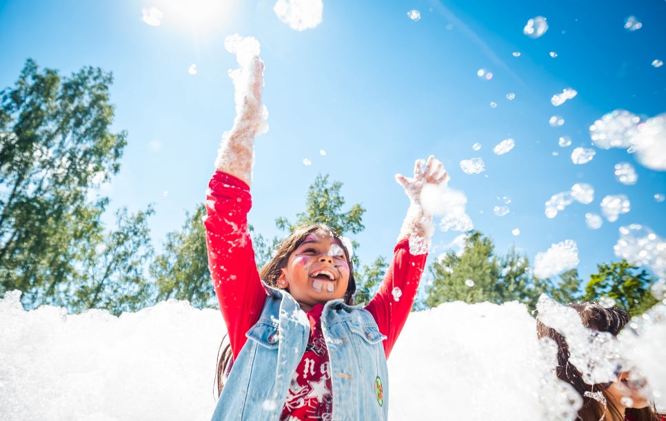 Una niña refugiada disfruta de una fiesta de espuma durante la celebración del Día Mundial del Refugiado en un centro de recepción de personas refugiadas en Rukla, Lituania. 