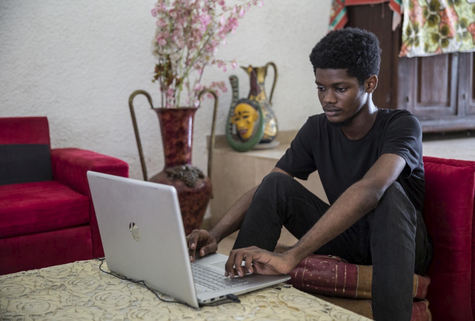 El diseñador gráfico marfileño O'Plérou trabaja en el emoji del Día Mundial del Refugiado 2020 en su computadora. 