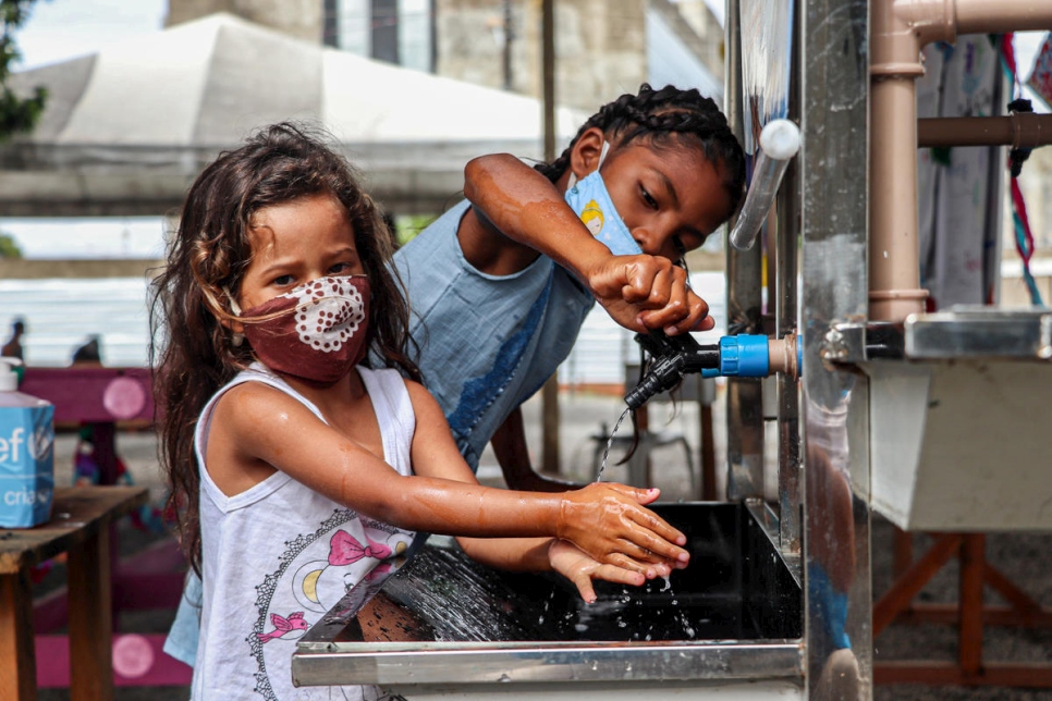 Niñas se lavan las manos en Brasil en la celebración del Día Mundial del Refugiado 2020.