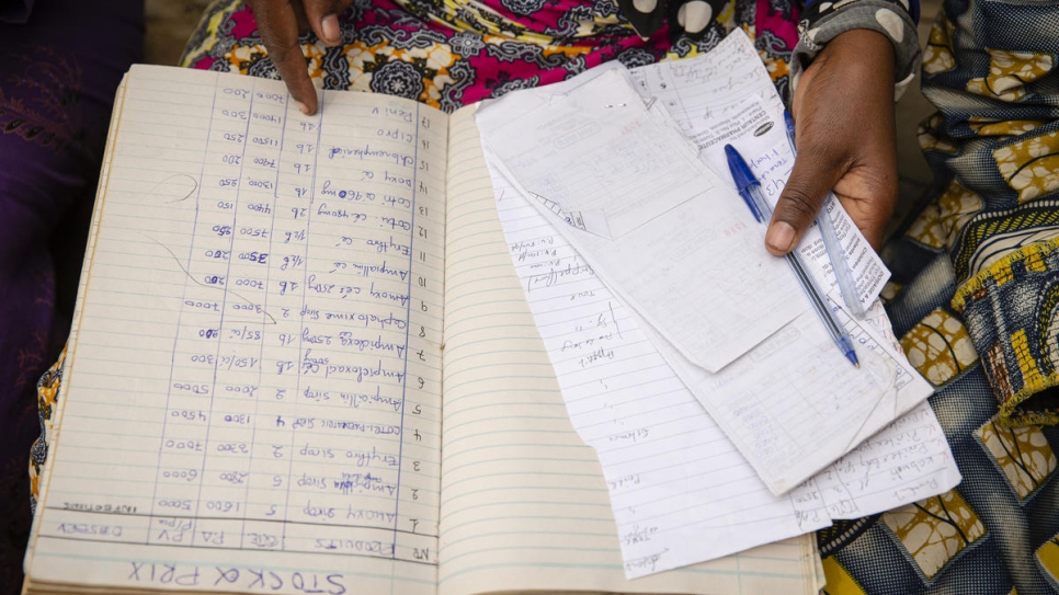 L'une des femmes réfugiées parrainée par Sabuni Françoise Chikunda passe en revue les archives du groupe de femmes fondé dans l'installation de Nakivale, en Ouganda. 