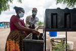 Burundian refugee Ishimagizwe Eliana washes her hands at the entrance ...