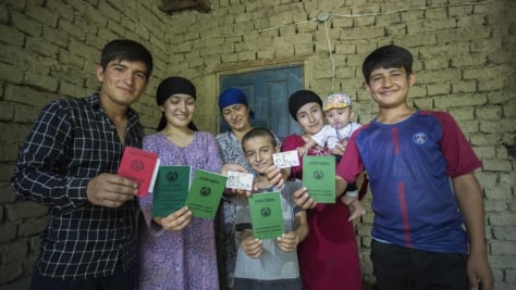 A leur domicile, les membres d'une famille anciennement apatride montrent leurs passeports récemment obtenus à Douchanbé, au Tadjikistan. 