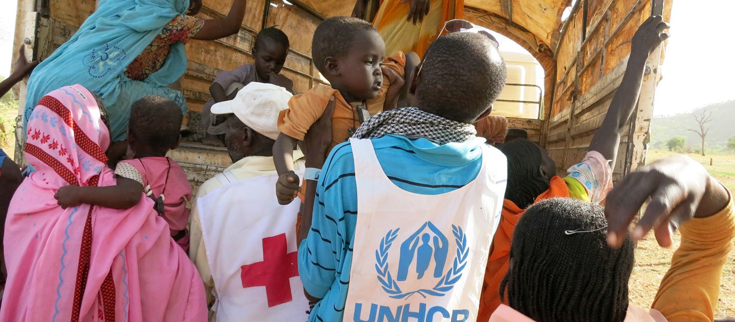 Chad / Sudanese refugees in Tissi / UNHCR staff together with the Chadian Red Cross are assisting refugees to board a truck who will take them to the newly established camp Abgadam. After their flight they stayed in an unsafe boarder area in makeshift shelters, many of them waiting for family members who are still in Sudan. While women and children will travel by truck, some of the men will be walking 2-3 with their livestock to the new camp which will offer enough space also for the animals. / UNHCR / R. Schoeffl / May 2013