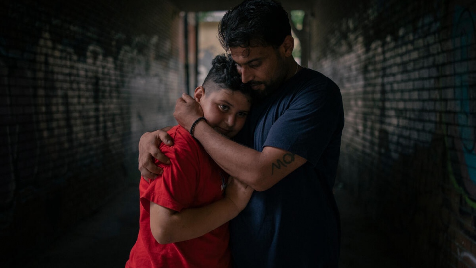 A Syrian asylum-seeker holds his son in front of the office of human rights lawyer, Nikola Kovačevic. 