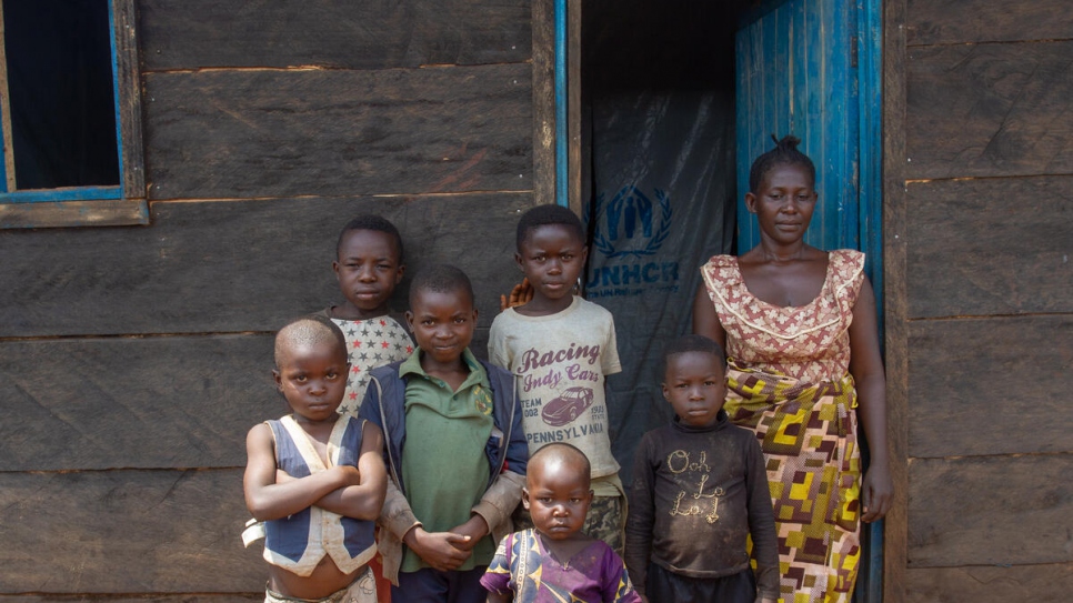 Elodie, a displaced Congolese woman stands with her children outside their durable shelter in Beni, in north-eastern Democratic Republic of the Congo.