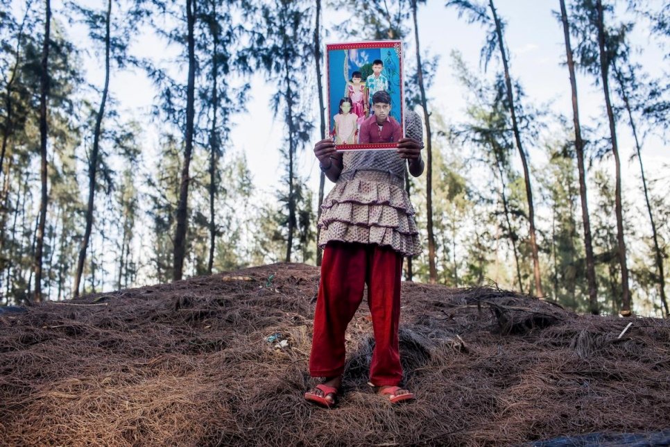 Bangladesh / Rohingya refugees / Youngest daughter of Rashid Ahmed, 45, holding a photo of her lost brother, Mohammad Faisal, 15. Her parents came to Bangladesh 13 years ago from Buthidaung, Sittwe, Myanmar to escape the bounded labor and the torture by the Security forces. Rashid Ahmed teaches at the local madrasa. He earns 4,000 to 5,000 BDT per month. But he can't afford his family of 12. Because of the poverty they sent their eldest son Mohammad Faisal to Malaysia in December 2013. But till now they haven't heard any news of him or 170 others from the same boat. Rashid Ahmed Spent around 8,000 BDT to look for his son but got no information. They think their son died in the sea. Rashid Ahmed says, 'Allah took him from us, what can we do. It was a mistake to send him.' / UNHCR / S.H. Omi / May 2014