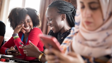 UNHCR, the UN Refugee Agency - Students attending a workshop on Berlin, chatting to each other and checking their phones during break. 