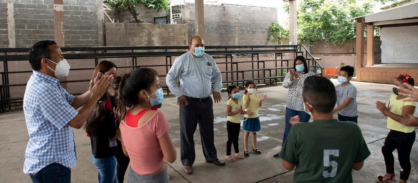 Educators play a game with children at a UNHCR-supported education centre in a high-risk area of Tegucigalpa, Honduras.
