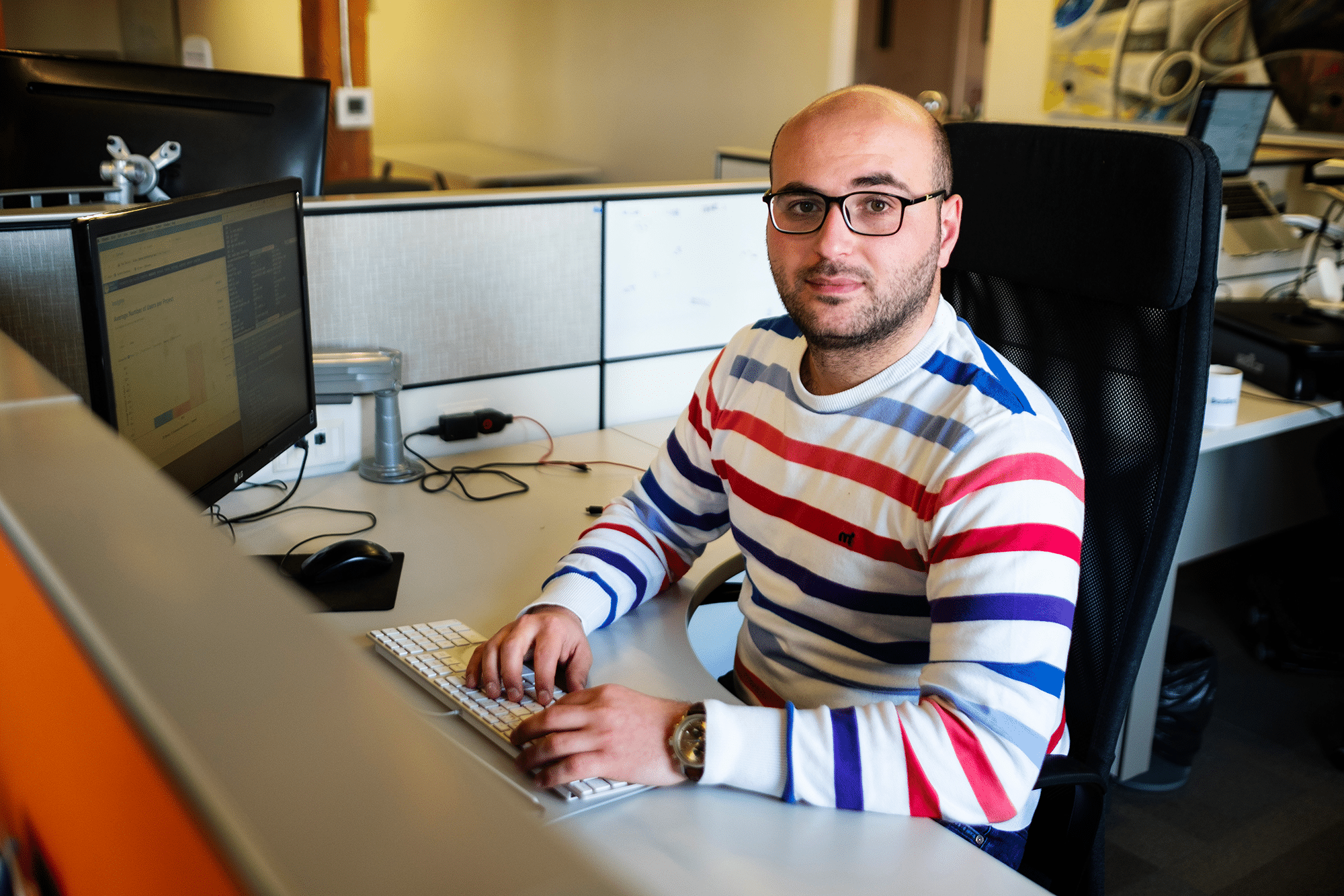 Syrian refugee Mohammed Hakmi is sitting at a desk.