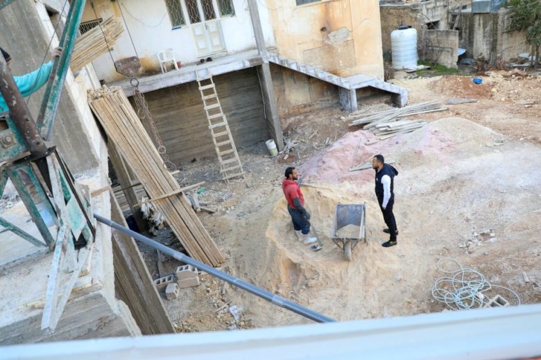 Deux hommes travaillent à la construction d'un abri.