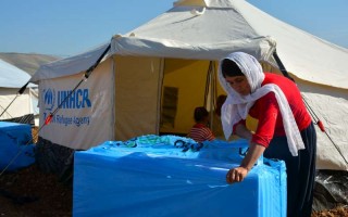 Mother-of-seven Laila opens a box containing insulation packaging that will keep her family warm this winter.