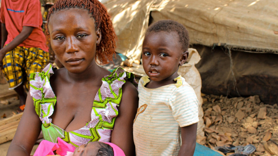 Central African refugee, Benitia, 23, holds her newborn baby girl as her daughter Safira stands next to her in the village of Ndu, in the Democratic Republic of Congo. 