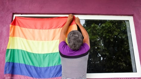 Electra and LGBT refugee from Honduras hanging up the rainbow flag at the LGBT module at La 72 migrant shelter in Tenosique, Tabasco, Mexico.